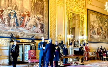 Lawrence and a wider room speaking to Prince William