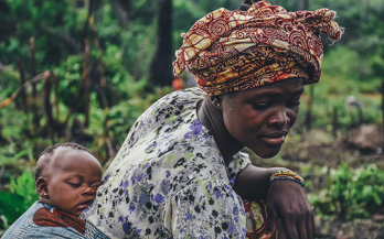 Mother working and holding baby on back Africa