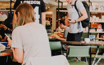 People eating in the cafeteria eating and chatting